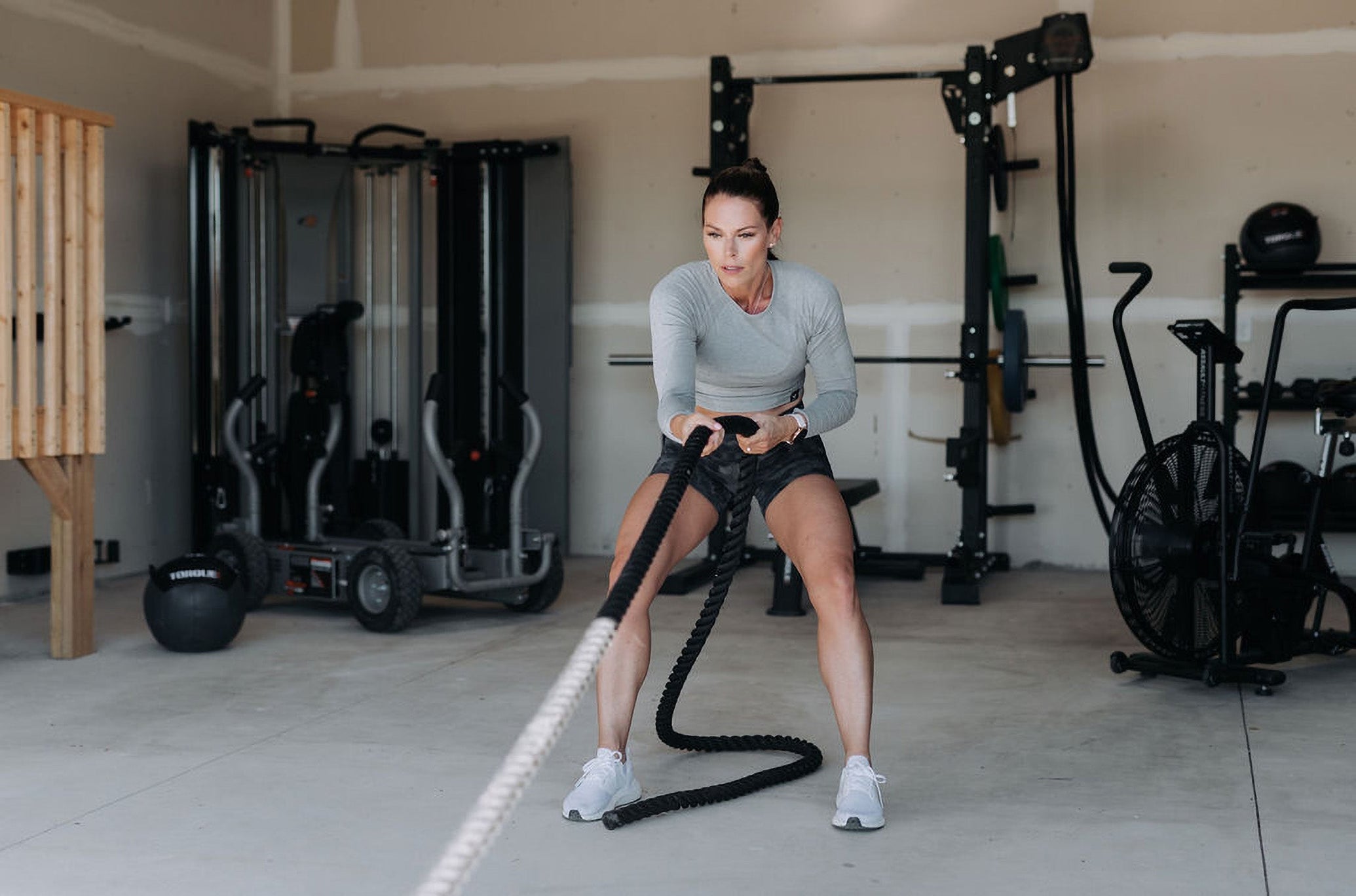 Woman Pulling TANK In Garage Gym With TANK Tow Rope Accessory