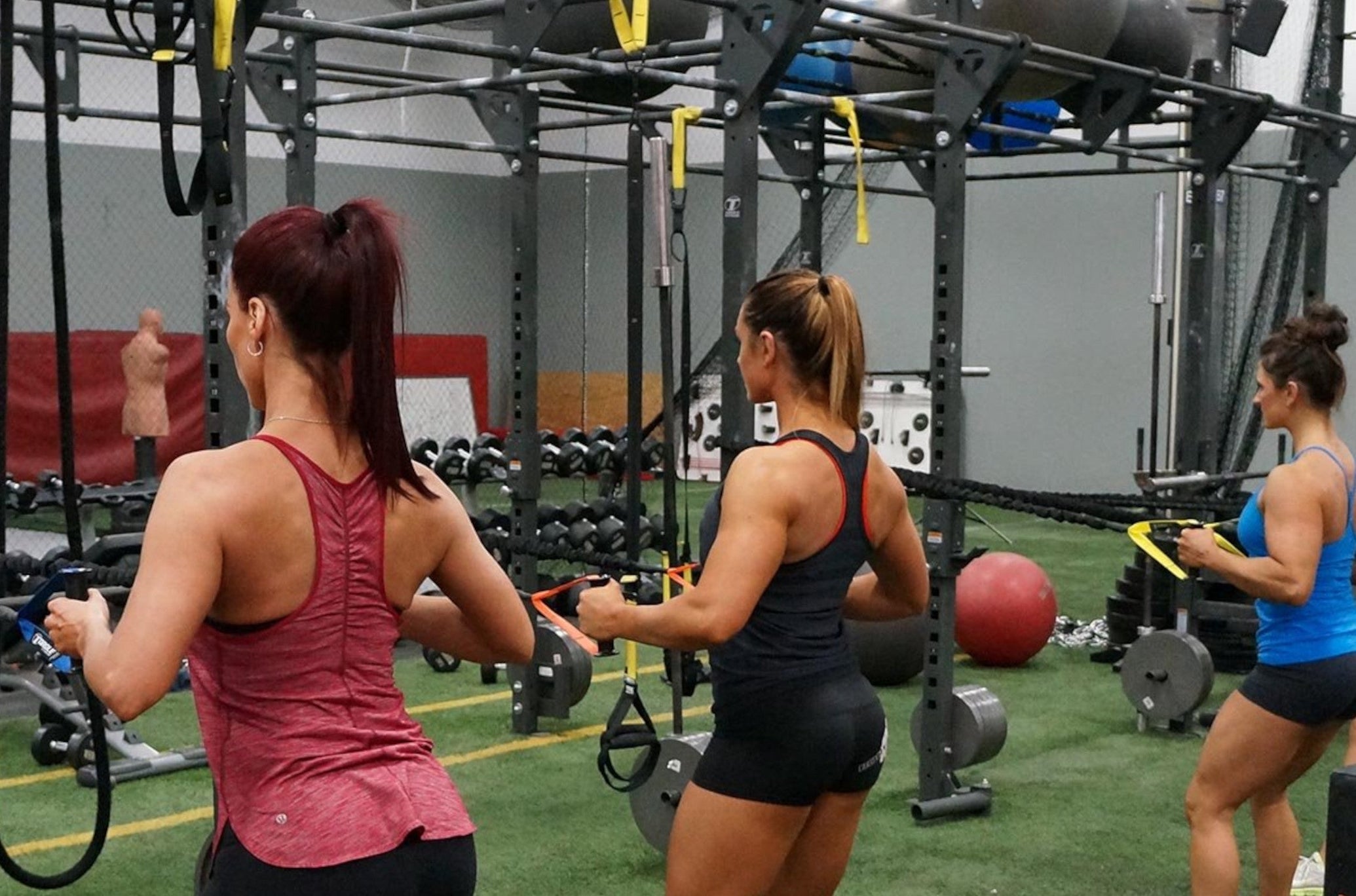 Women Training With Torque Two Handle Power Tubes On Racks