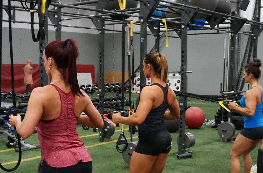 Women Training With Torque Two Handle Power Tubes On Racks